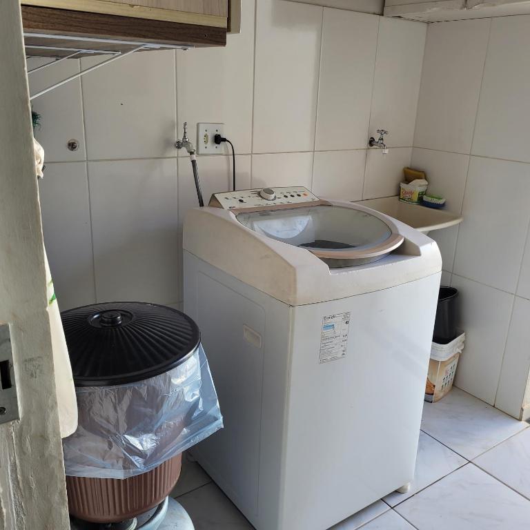 - Lavadora en una habitación con cubo de basura en Casa aconchegante, en Franca