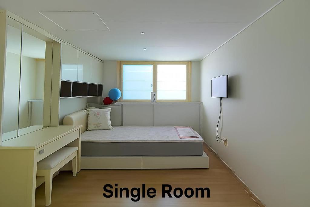 a small room with a bed and a large mirror at Vivy1 in Busan