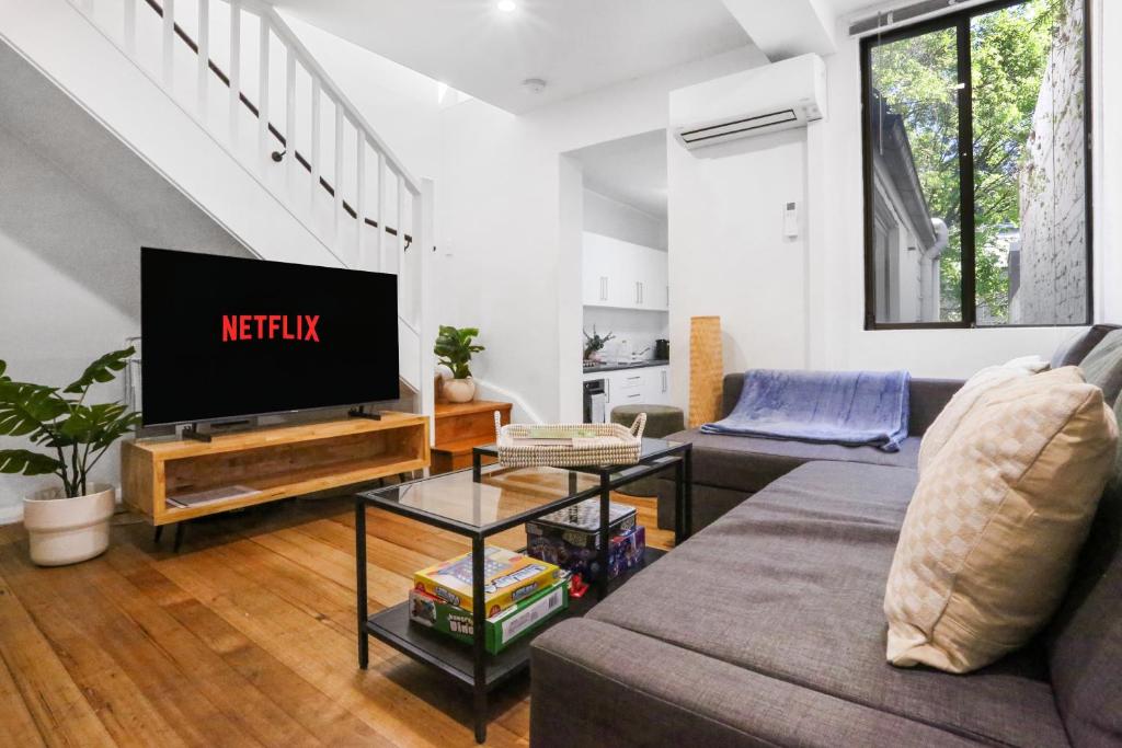a living room with a couch and a tv at Pyrmont NSW - 3 Bedroom Apartment- 8 Guests - NetFlix in Sydney