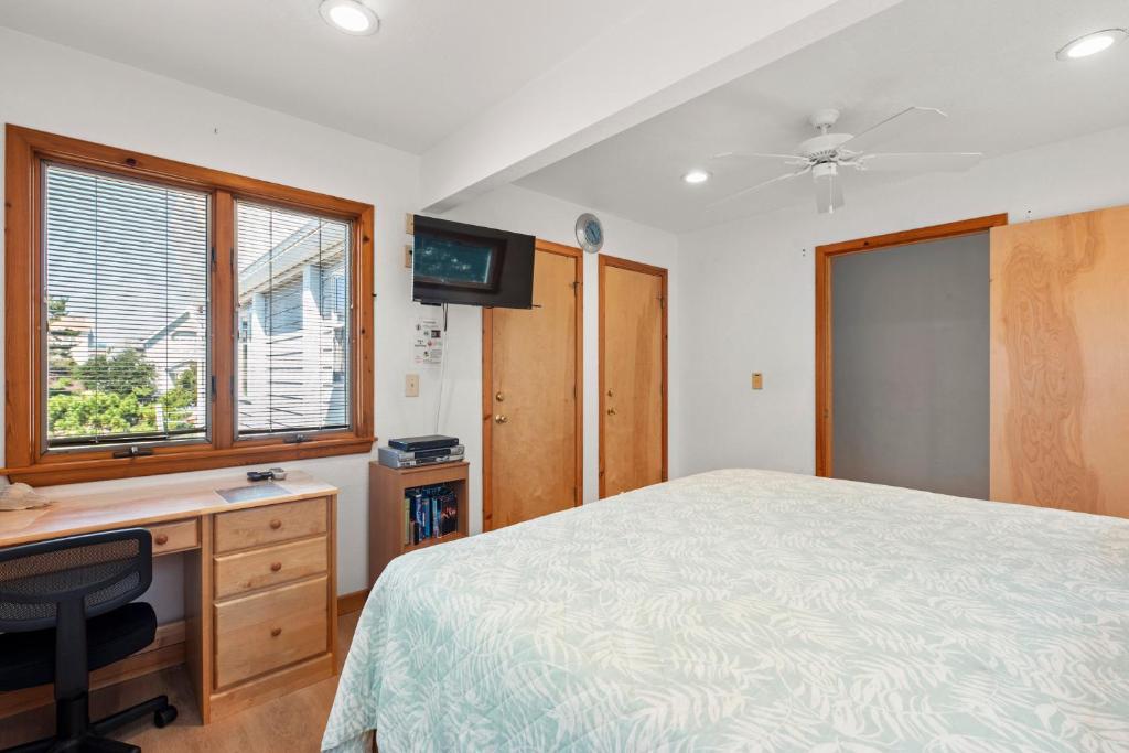 a bedroom with a bed and a desk and a tv at DU410: Family Tradition in Duck