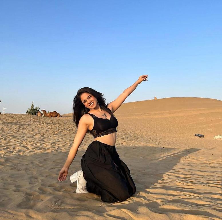 una mujer con un vestido negro en el desierto en malik tour & travel jaisalmer, en Jaisalmer