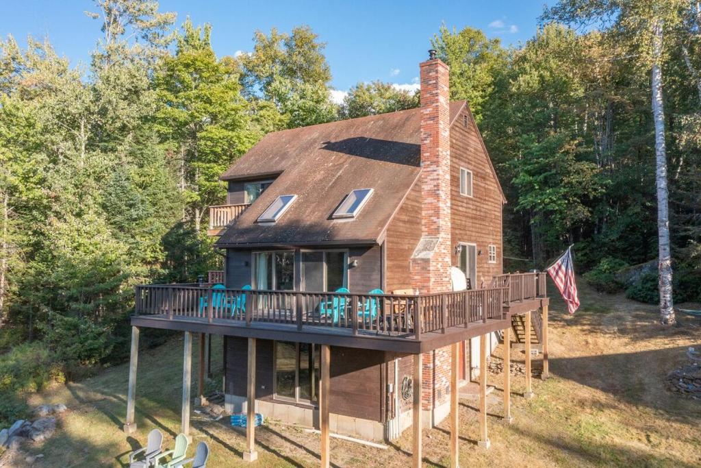 a house with a wrap around porch and a deck at Your 5-BR White Mountain Retreat in Littleton