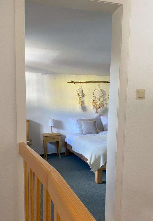 a bedroom with a white bed and a staircase at Auszeit Ferienhaus Nr 2 in Sierscheid