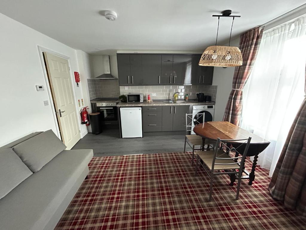 a kitchen and living room with a couch and a table at Chloes Holiday Apartments in Inverness