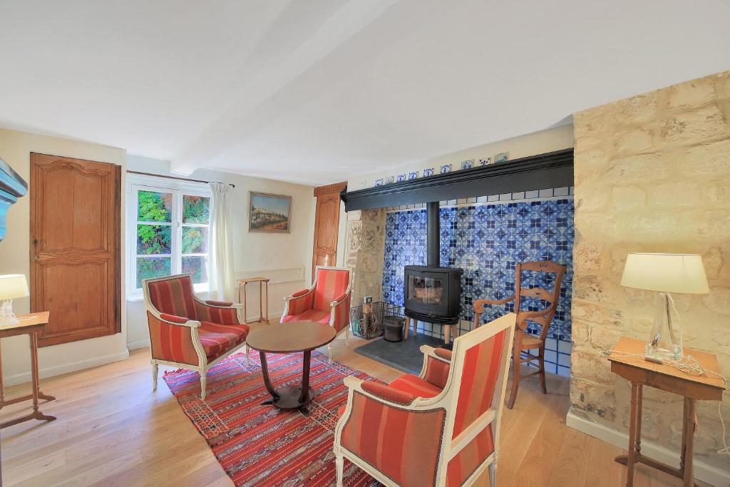 a living room with a table and chairs and a fireplace at Mouchette - Avec grand jardin in Créquy