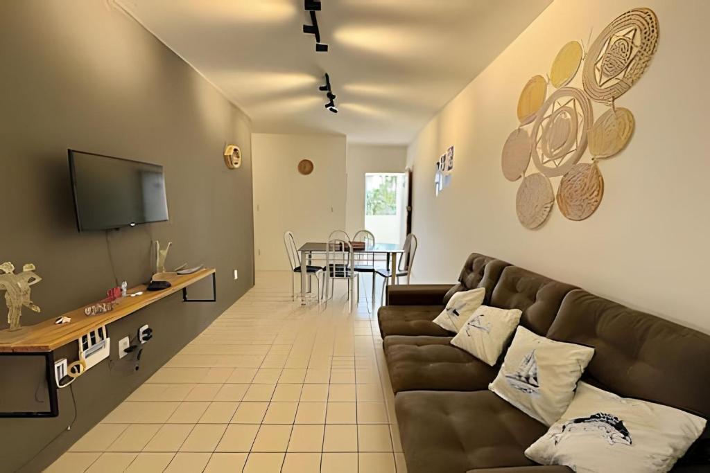 salon z kanapą i stołem w obiekcie Lindo Apê dois quartos em frente ao mar na Barra de São Miguel w mieście Barra de São Miguel