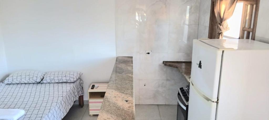 a kitchen with a bed and a refrigerator in a room at Nova Amsterdam aluga eventos in Guarulhos