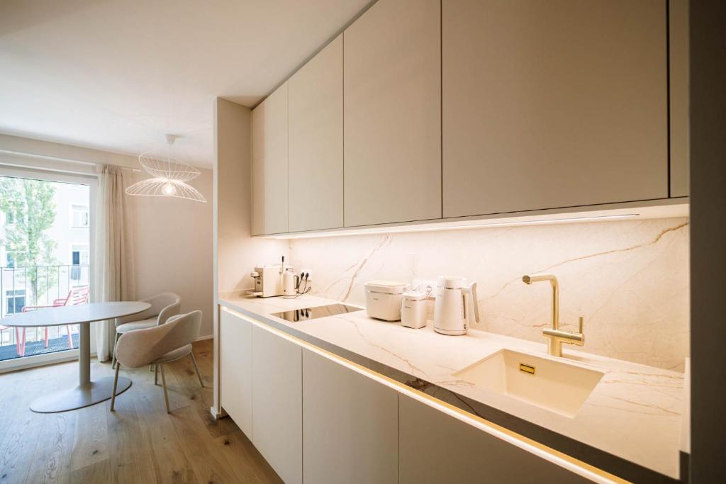 a kitchen with a counter with a sink and a table at Lindgold in Munich