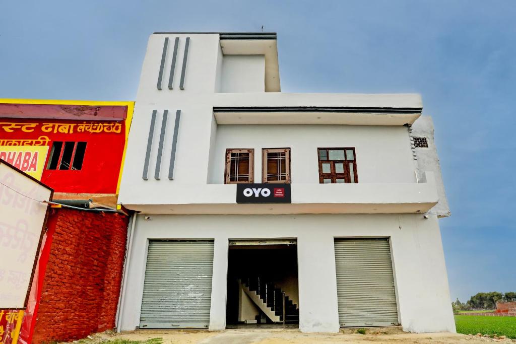 a white building with an open door at Hotel O The Happy Homestay in Morādābād