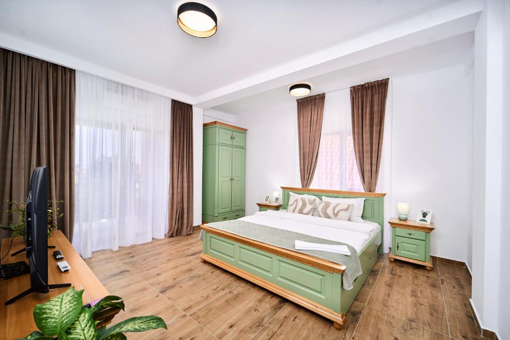 a bedroom with a green bed and a television at Primaverii Dream Residence in Chişoda