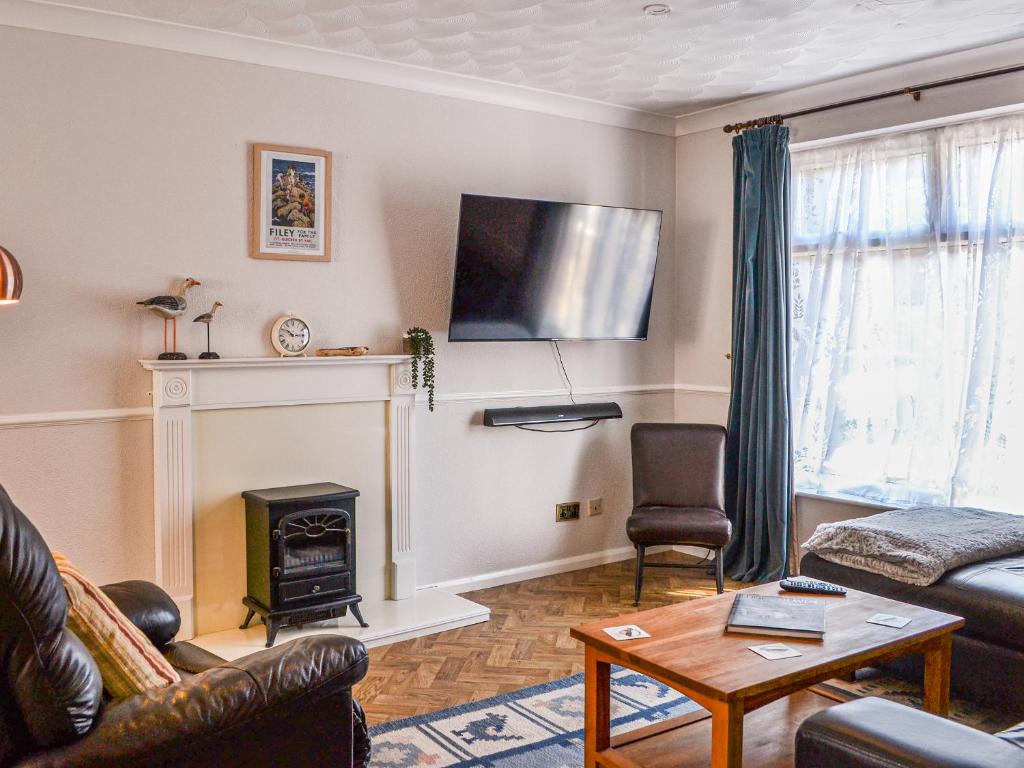 a living room with a couch and a fireplace at The Sandpiper in Filey