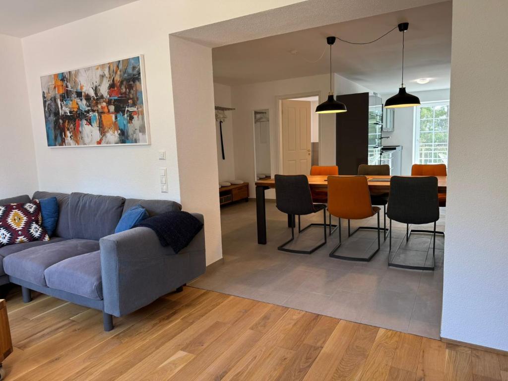 ein Wohnzimmer mit einer Couch und einem Tisch und Stühlen in der Unterkunft Ferienwohnung in Oberschwaben in Schemmerhofen