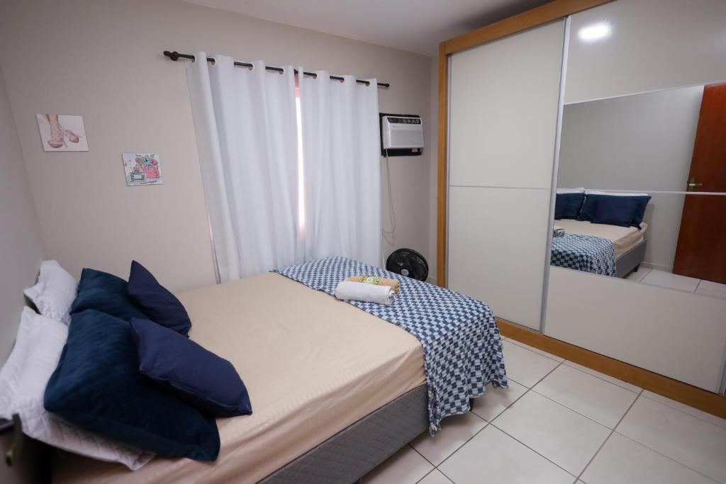 une petite chambre avec un lit et un miroir dans l'établissement Apartamento moderno e super aconchegante, à Campos dos Goytacazes