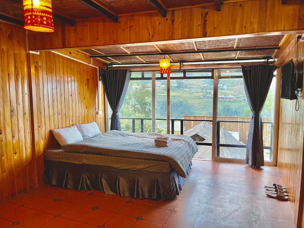a bedroom with a bed and a large window at Sky View Homestay in Tả Van