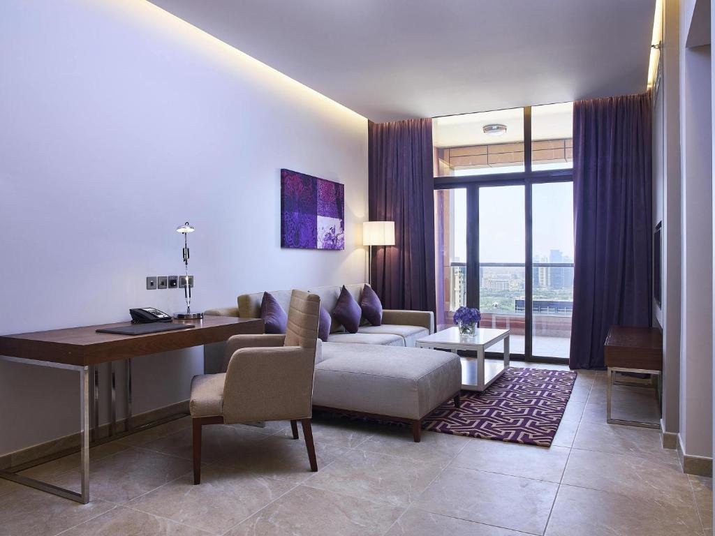 un salon avec un canapé et une table dans l'établissement Mercure Dubai Barsha Heights Hotel Suites And Apartments, à Dubaï