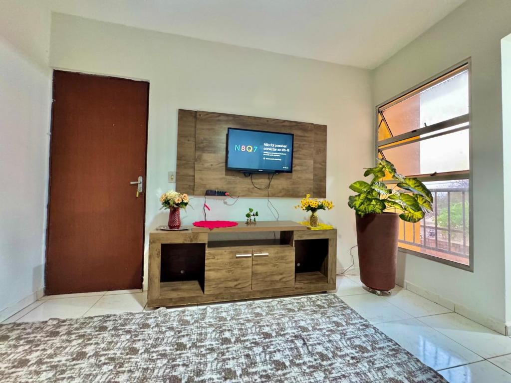 a living room with a flat screen tv on a wall at Perto do aeroporto, estádio e Praia dos Buritis in Palmas