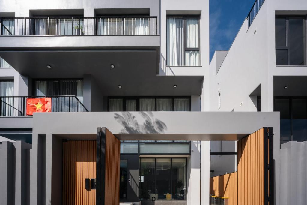 an external view of a white building with wooden doors at TS Villa in Danang