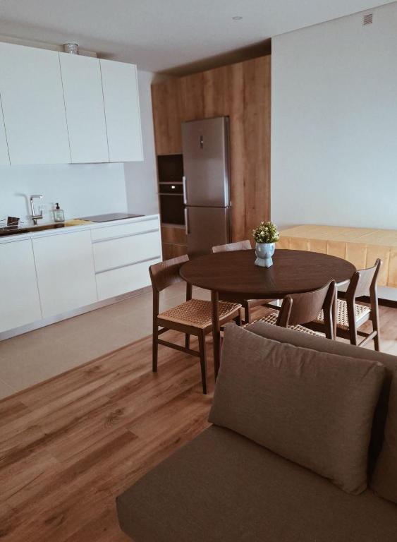 a kitchen with a table and chairs and a refrigerator at Vivas House in Esposende