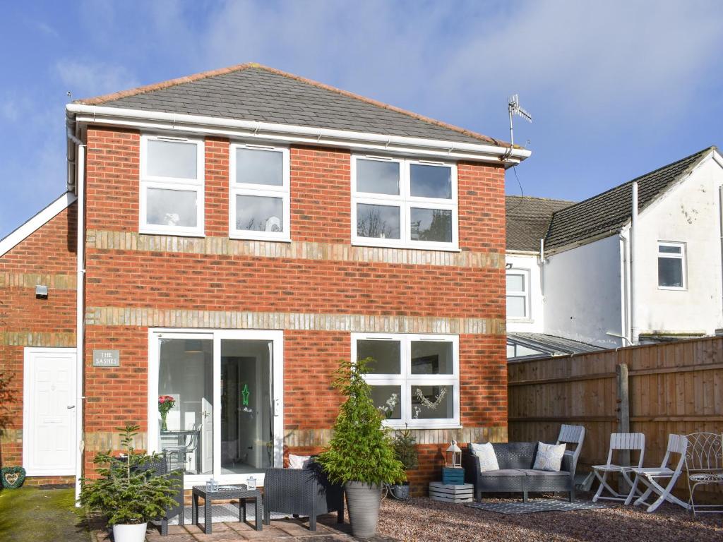 a red brick house with a patio in front of it at Apartment 1 - Uk42622 in Poole