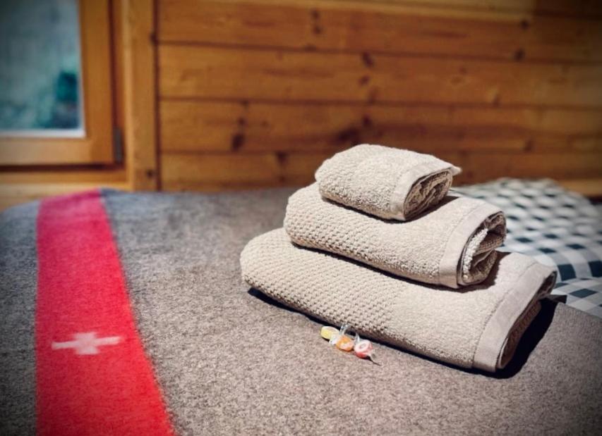 a pile of towels sitting on top of a bed at Hüttli Chalet mit atemberaubendem Weitblick in Naters