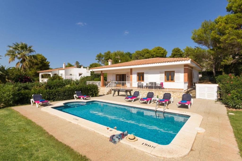 a house with a swimming pool in front of a house at Villa Camomila Tomas by Villa Plus in Santo Tomás