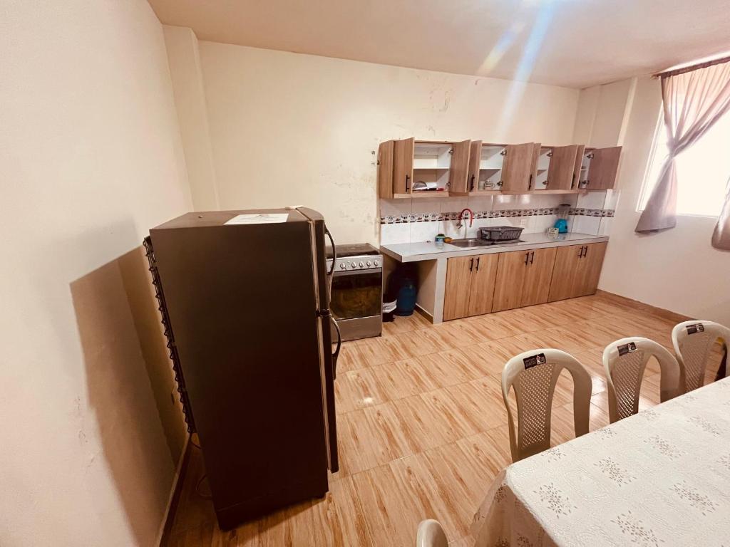 a kitchen with a black refrigerator in a room at Seguridad para la familia in Tena