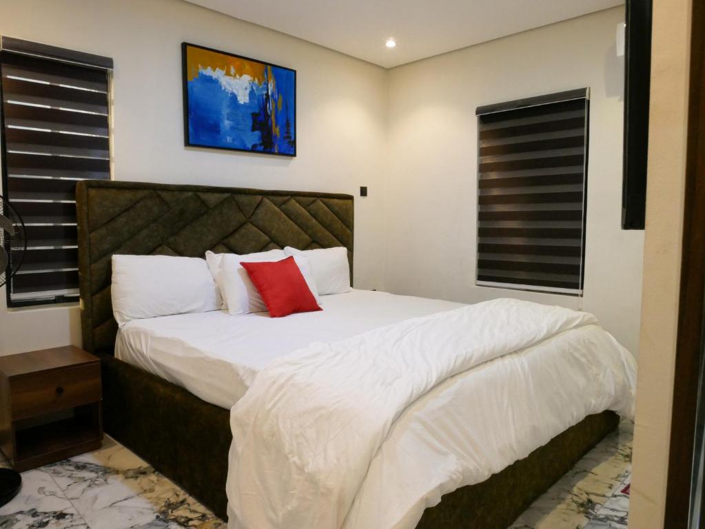 a bedroom with a large bed with a red pillow at LV-21 Service Apartment M04b in Lagos