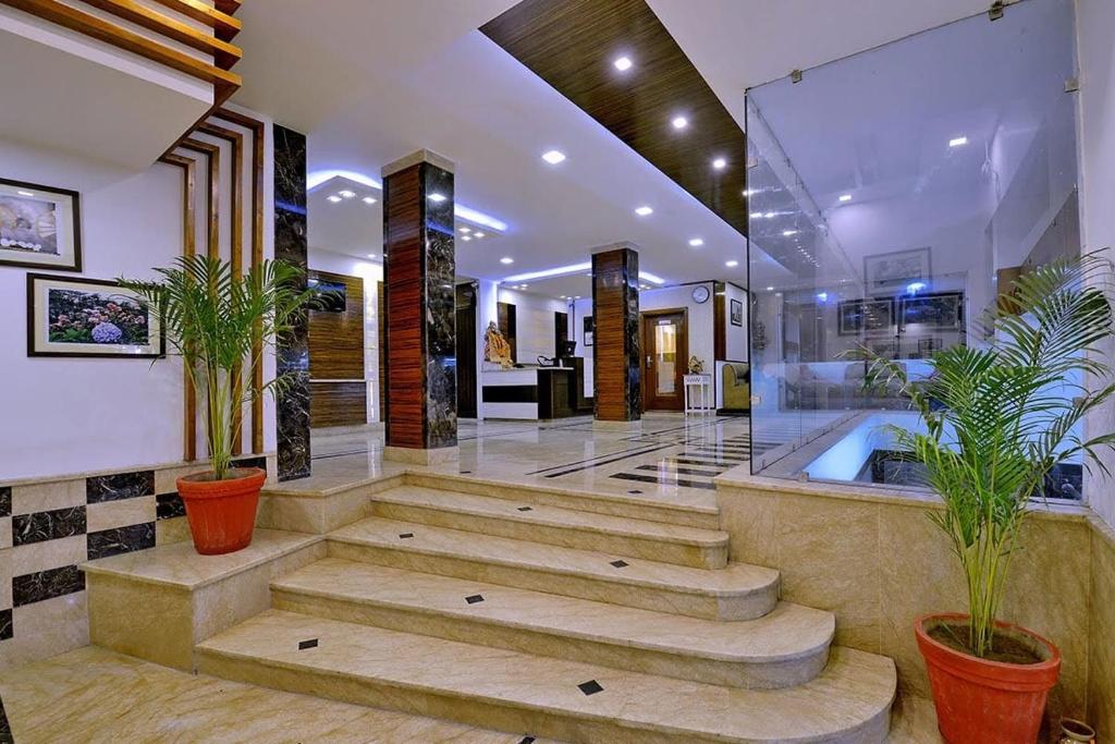 a large bathroom with a tub and potted plants at Hotel Mayur by RoomsInc Katra in Katra