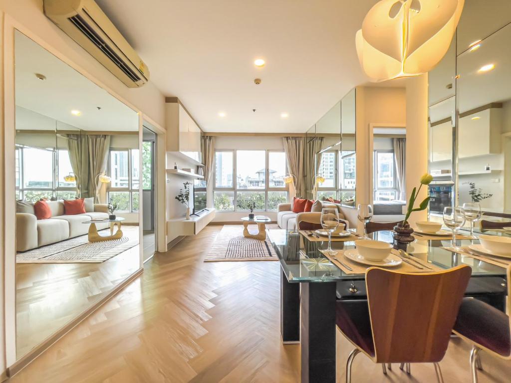 a living room with a dining table and a couch at Elegant Stay near IconSiam l High-speed WiFi l BTS Wongwian Yai in Godown