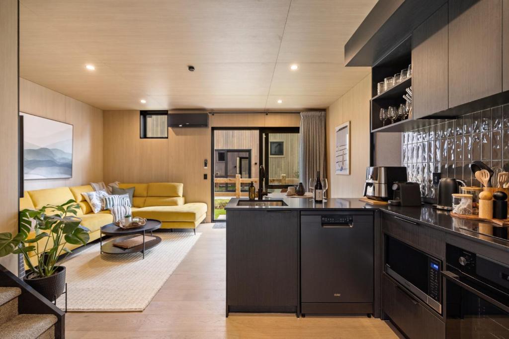 a kitchen and living room with a couch at Villa XV Stylish and Contemporary Escape in Queenstown Airport