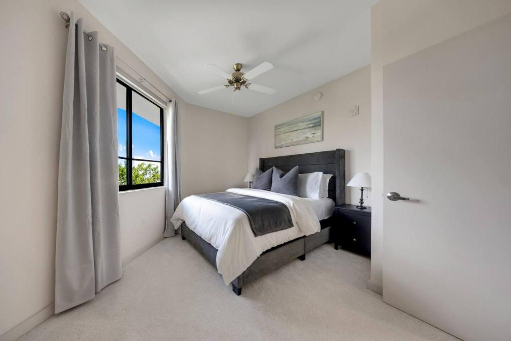 a white bedroom with a bed and a window at Aqua Luxe in DTWN 3 Min From Las Olas in Fort Lauderdale