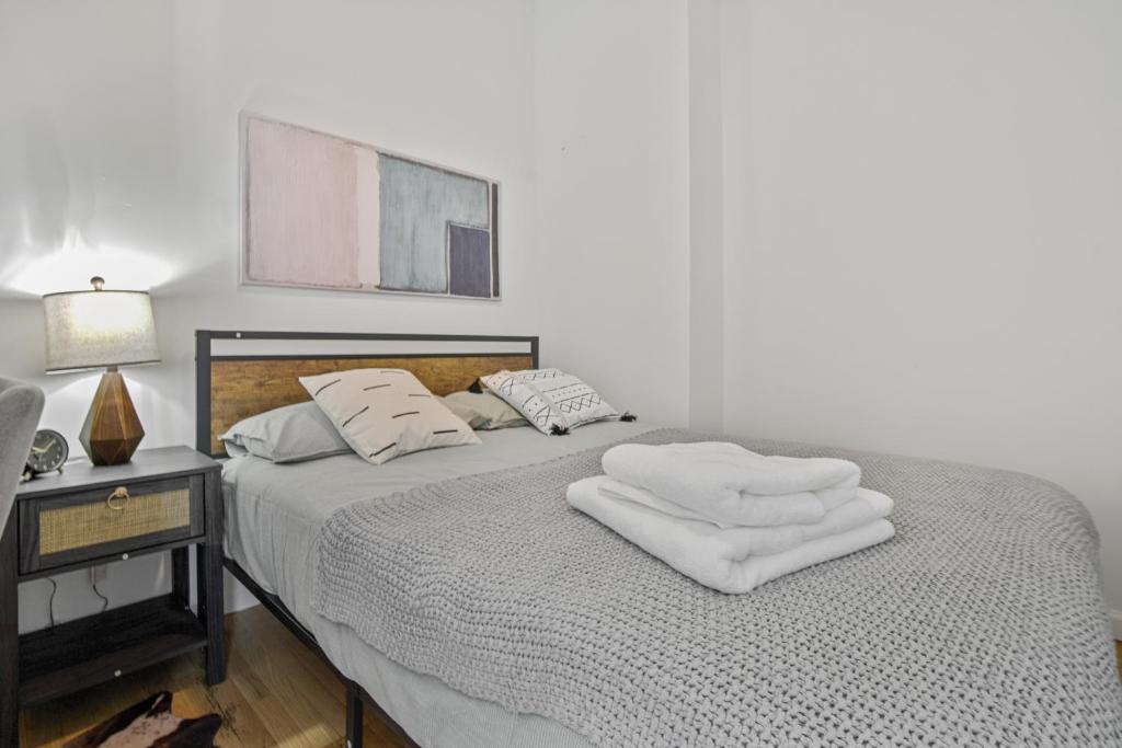 a bedroom with a bed with two white towels on it at 2 BD Tranquil Unit close to Central Park in New York