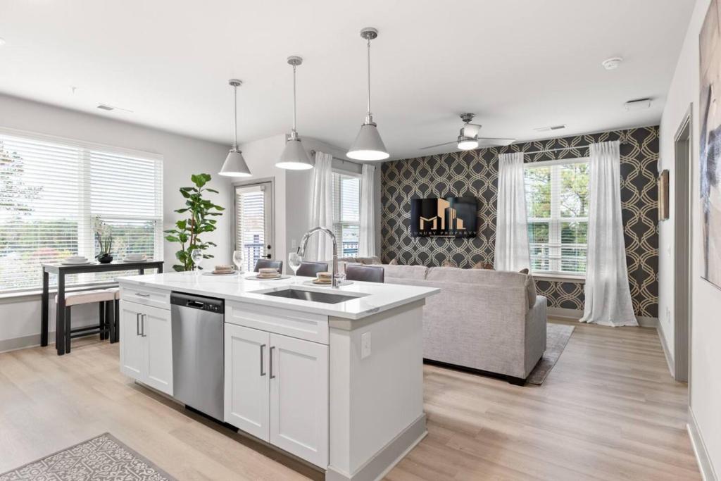 a kitchen with a sink and a couch in a room at The Icon 5 Min From Downtown in Wilders Grove