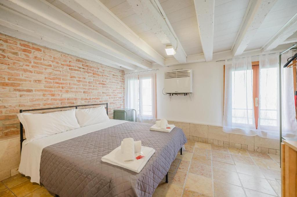 a bedroom with a bed and a brick wall at Balastro Design Rooms - Venice City Center in Venice