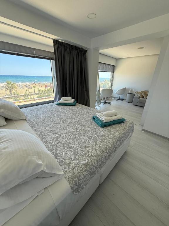 une chambre avec un grand lit avec une grande fenêtre dans l'établissement Marimar2 paradise by the Sea, à Larnaka