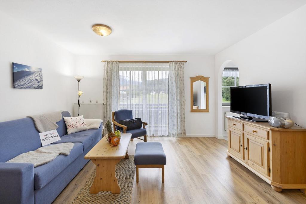 オーバーアウドルフにあるFewo Brünnstein - Nr 35 Romantikの青いソファとテレビのあるリビングルーム