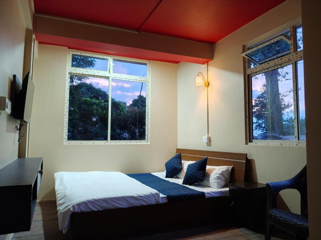 a bedroom with two beds and two windows at Totola Premium Stay in Beliaghata