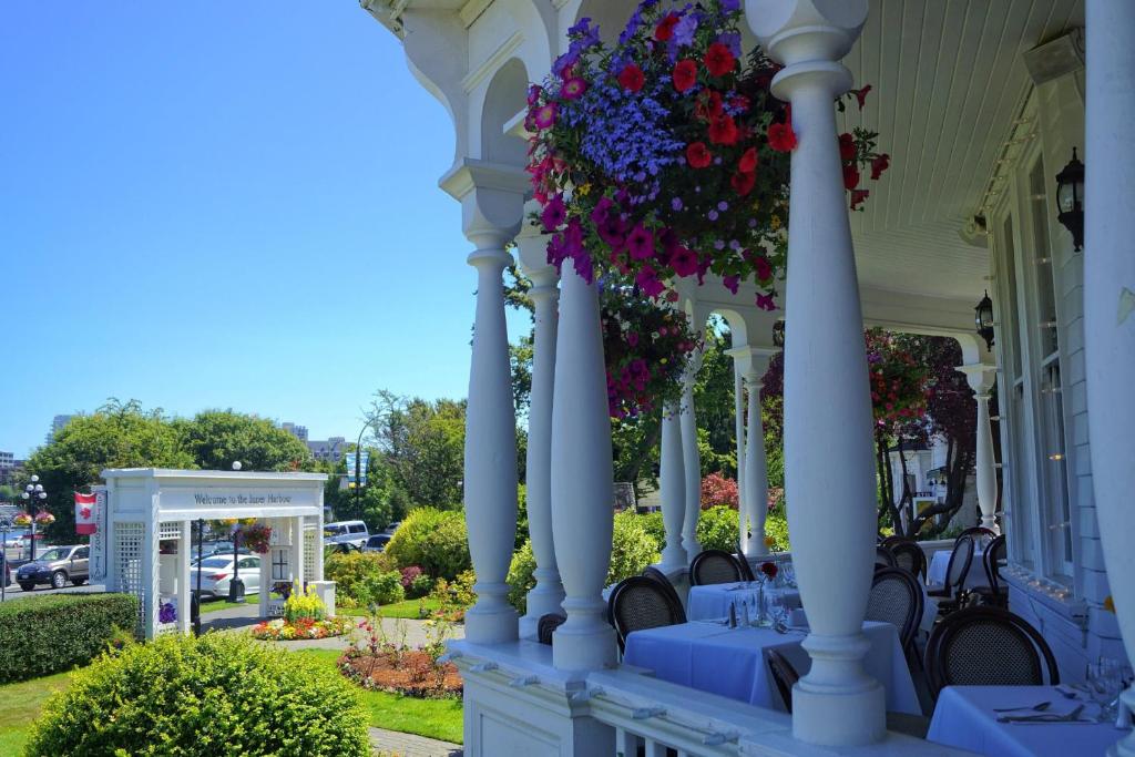 a porch of a house with blue tables and flowers at Pendray Inn and Tea House in Victoria