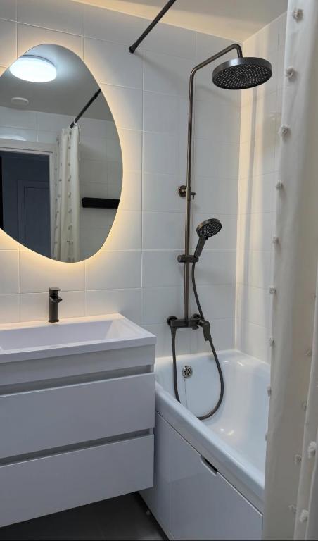 a bathroom with a shower and a sink and a mirror at Confetti in Kremenchuk