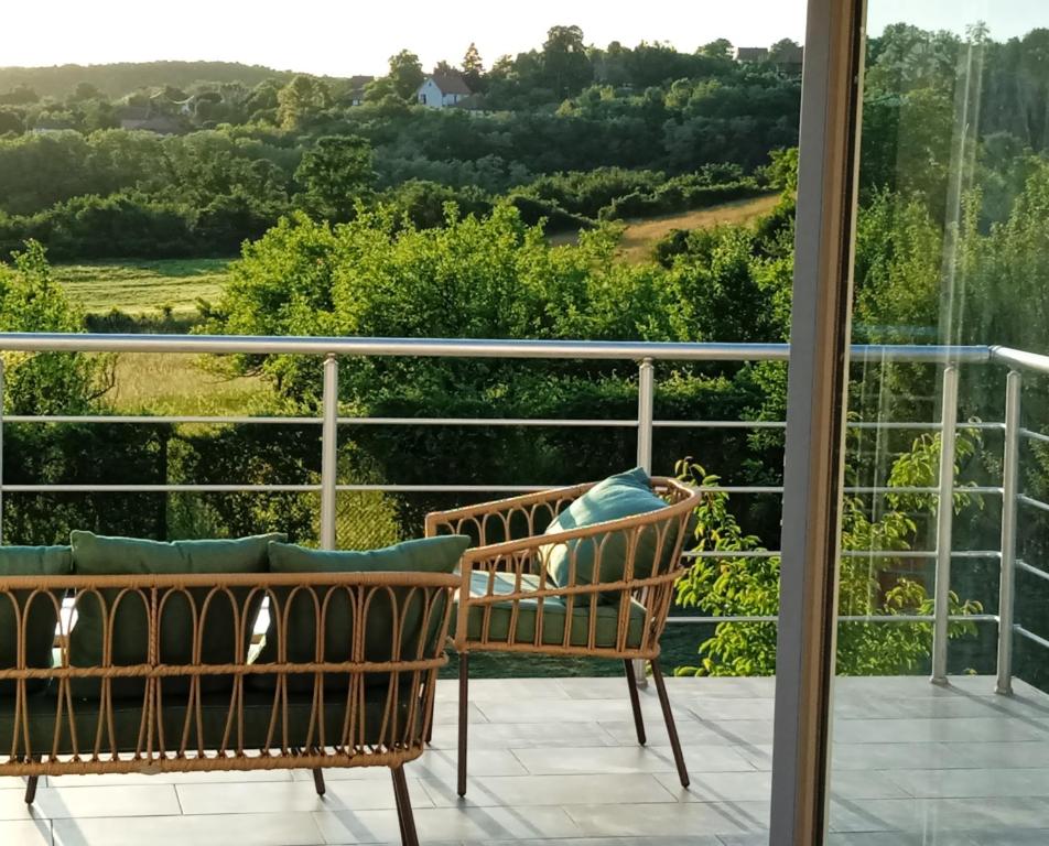 two chairs on a balcony looking out at the countryside at ART HOUSE Kosmaj 2 in Sopot