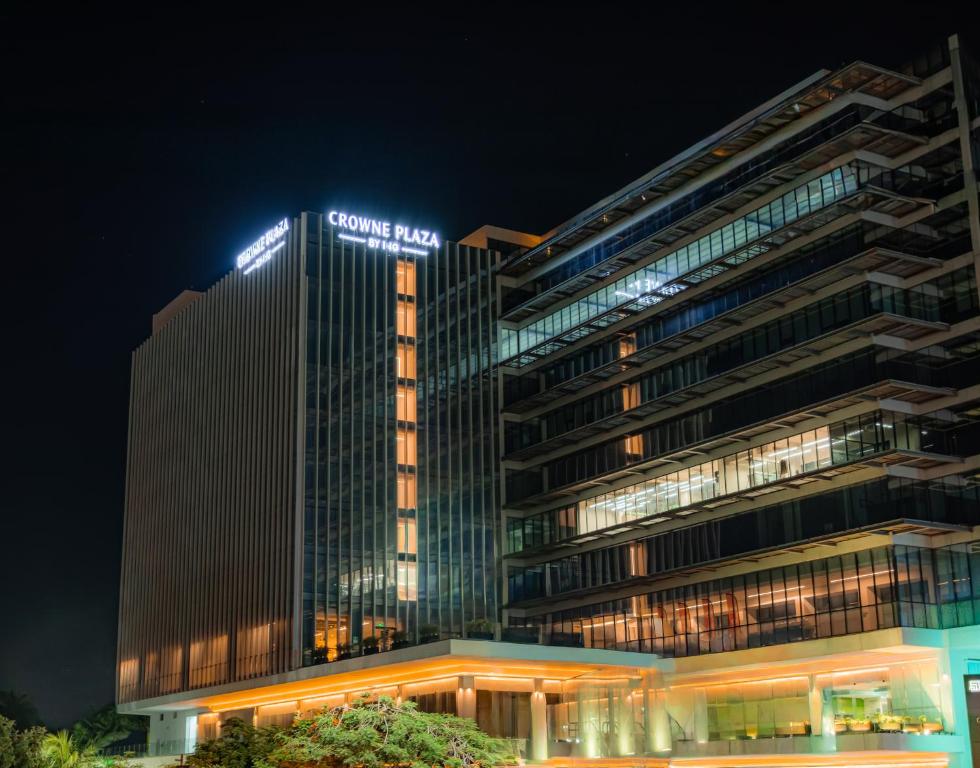 a tall building with a sign on it at night at Crowne Plaza Merida by IHG in Mérida