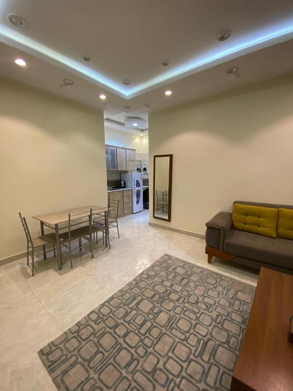 a living room with a couch and a table at شقق برج ملاذ للشقق المخدومة 