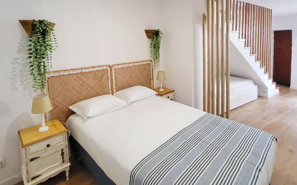 Un dormitorio con una cama grande y una escalera. en Casa Miradouro das Beatas, en Elvas