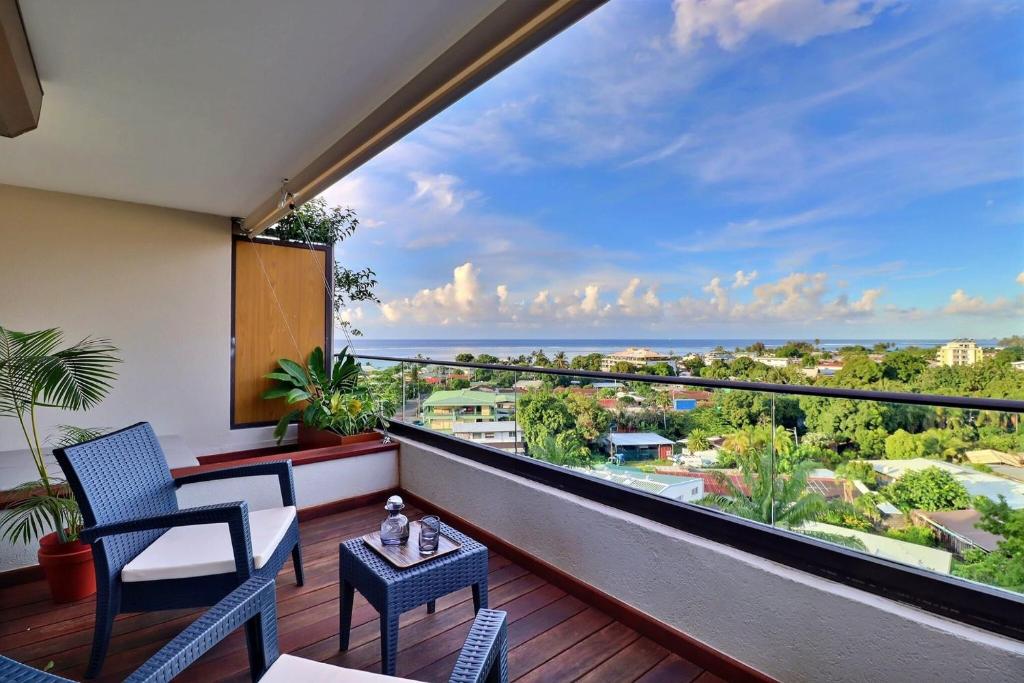 Un balcón con sillas y vista al mar. en Mahana Suite Sea & Mountain View, en Papeete