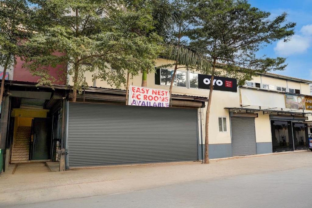 バンガロールにあるHotel O Easynest Bharathi cityの道路標識の横に看板を掲げている店