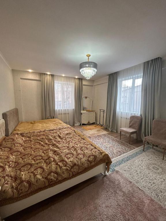 a bedroom with a large bed and a chandelier at House Halal Hotel in Almaty