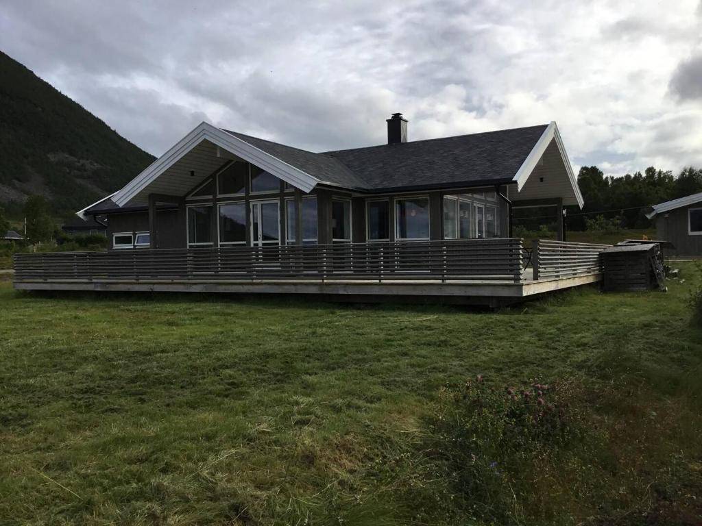 a large house with a large porch on a field at Tromsø idyllic cabin in Tromsø
