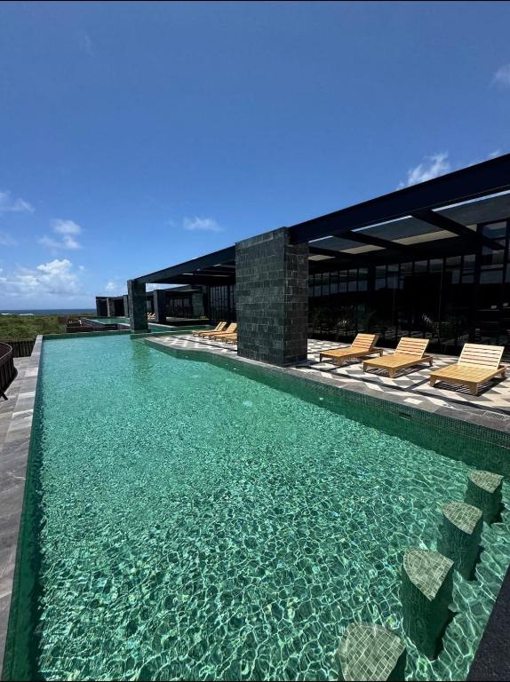 a swimming pool with chairs and a building at Amira District in Cedro