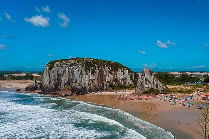 Passo De TorresにあるApartamento 600 metros do mar, 14 minutos do centro de Torresの海辺の浜辺の人々