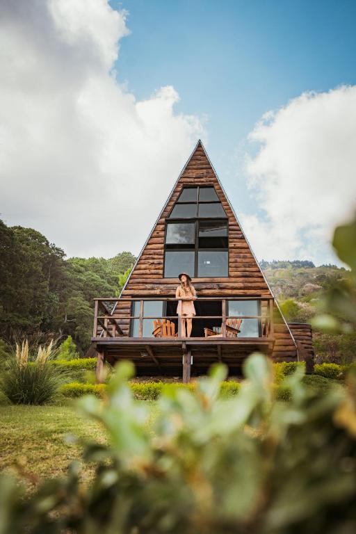 a woman standing on the porch of a house at VIU Boutique Cabins in San Salvador